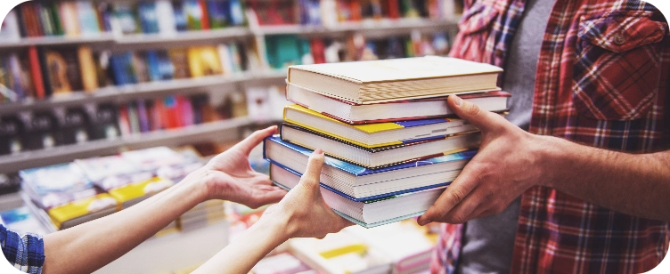 Six stacked books being passed from one person to another at a library