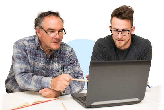 TWO MEN,,ONE YOUNGER THAN THE OTHER SIT LOOKING AT A COMPUTER SCREEN